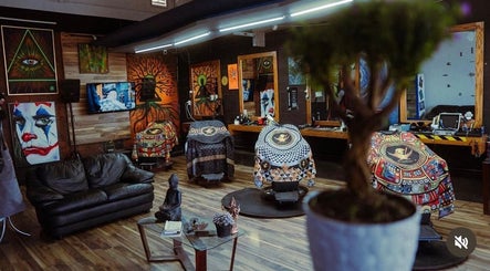 Interior artístico y moderno de GABRIEL BARBERSHOP en Chihuahua, Chihuahua, MX con decoraciones vibrantes y cómodas sillas.