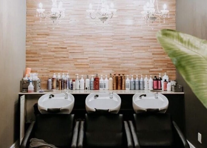 Elegant salon wash station at Melissa’s Artistry Collective, North West, North West, ZA with chandeliers.