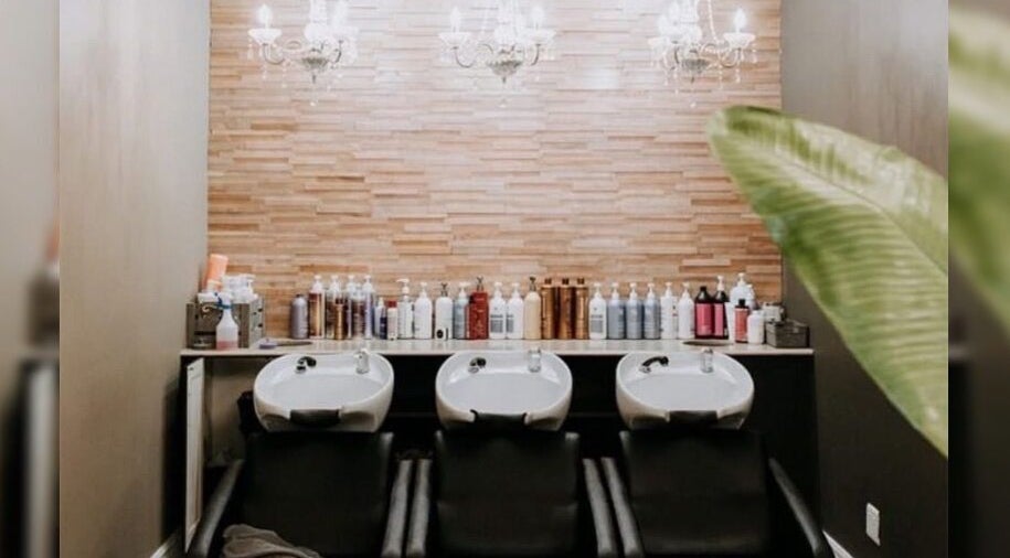 Elegant salon wash station at Melissa’s Artistry Collective, North West, North West, ZA with chandeliers.