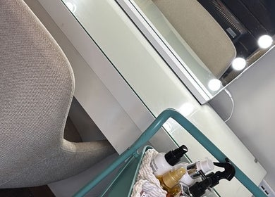 Elegant vanity setup at The Blowout Boutique, Leeds, England, GB, showcasing beauty products under bright lights.