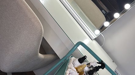 Elegant vanity setup at The Blowout Boutique, Leeds, England, GB, showcasing beauty products under bright lights.