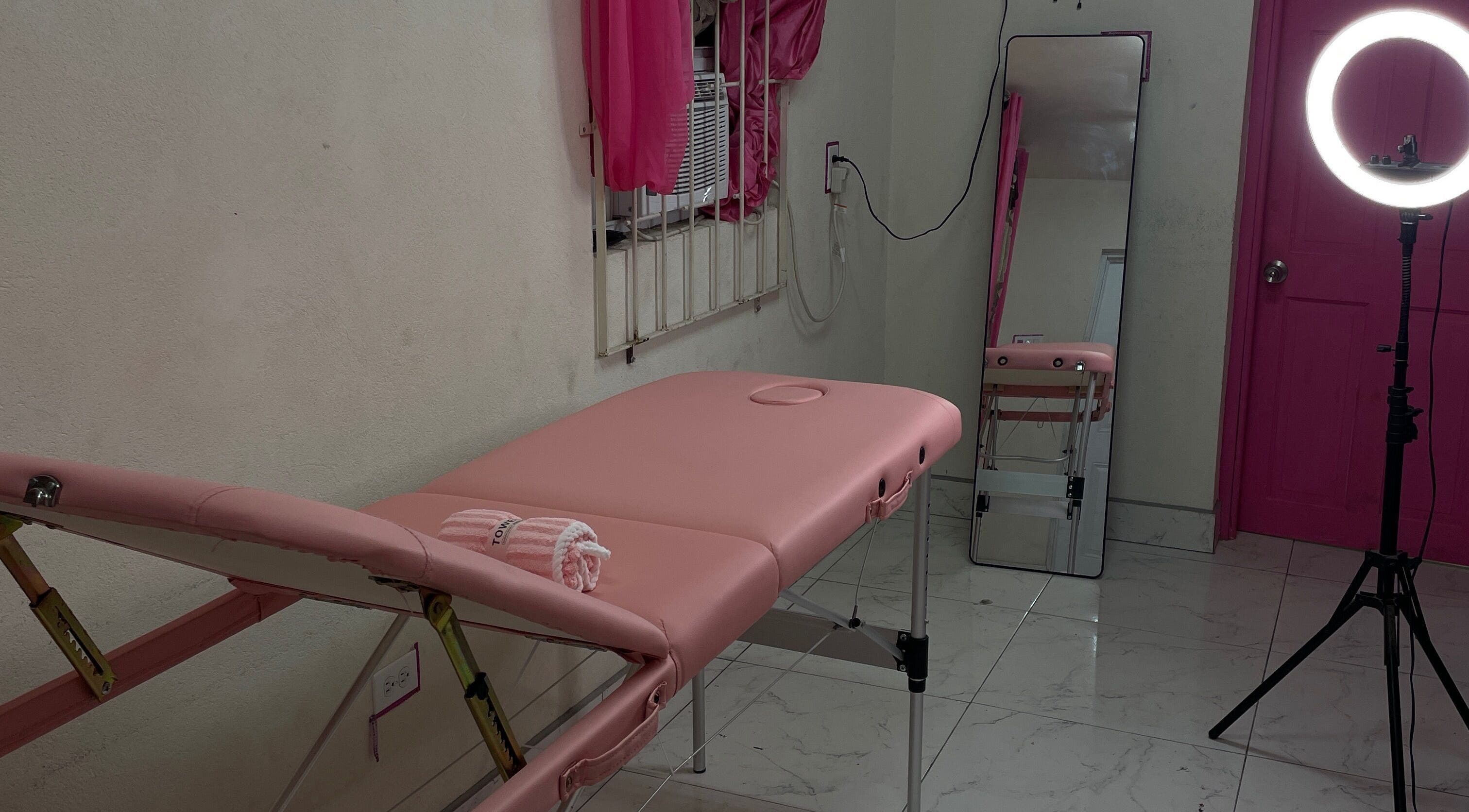 Cozy treatment room at Luxe Gleam Studio in Bridgetown, Saint Michael, BB with pink massage table and ring light.