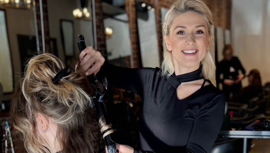 Stylist curling hair at Dina Laurent Hair | Mind-Beauty Studio, Coquitlam, British Columbia, CA.