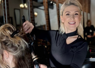 Stylist curling hair at Dina Laurent Hair | Mind-Beauty Studio, Coquitlam, British Columbia, CA.