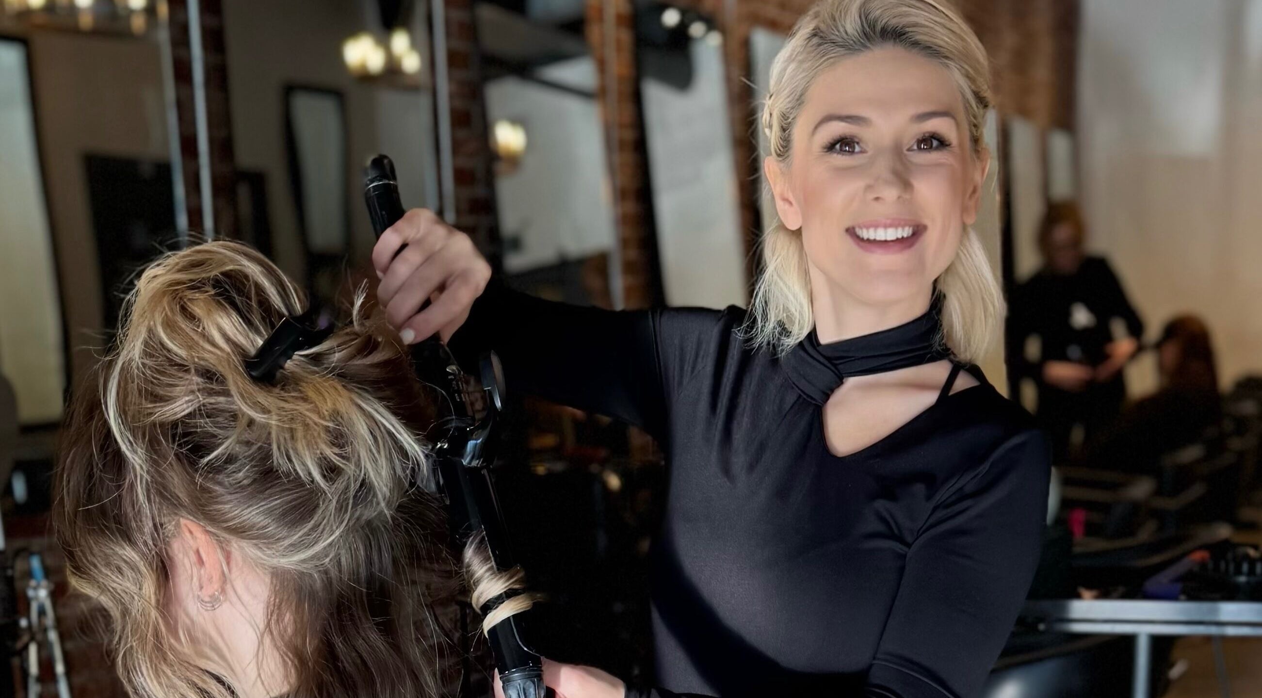 Stylist curling hair at Dina Laurent Hair | Mind-Beauty Studio, Coquitlam, British Columbia, CA.