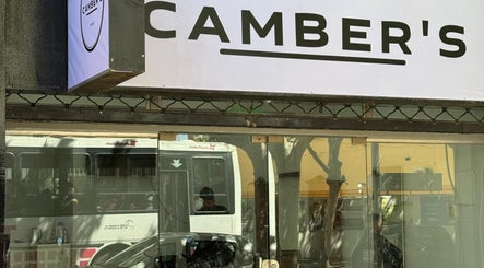 Fachada de Charlie, salón de belleza en San Juan, San Juan, AR, con un cartel exterior reflejándose.