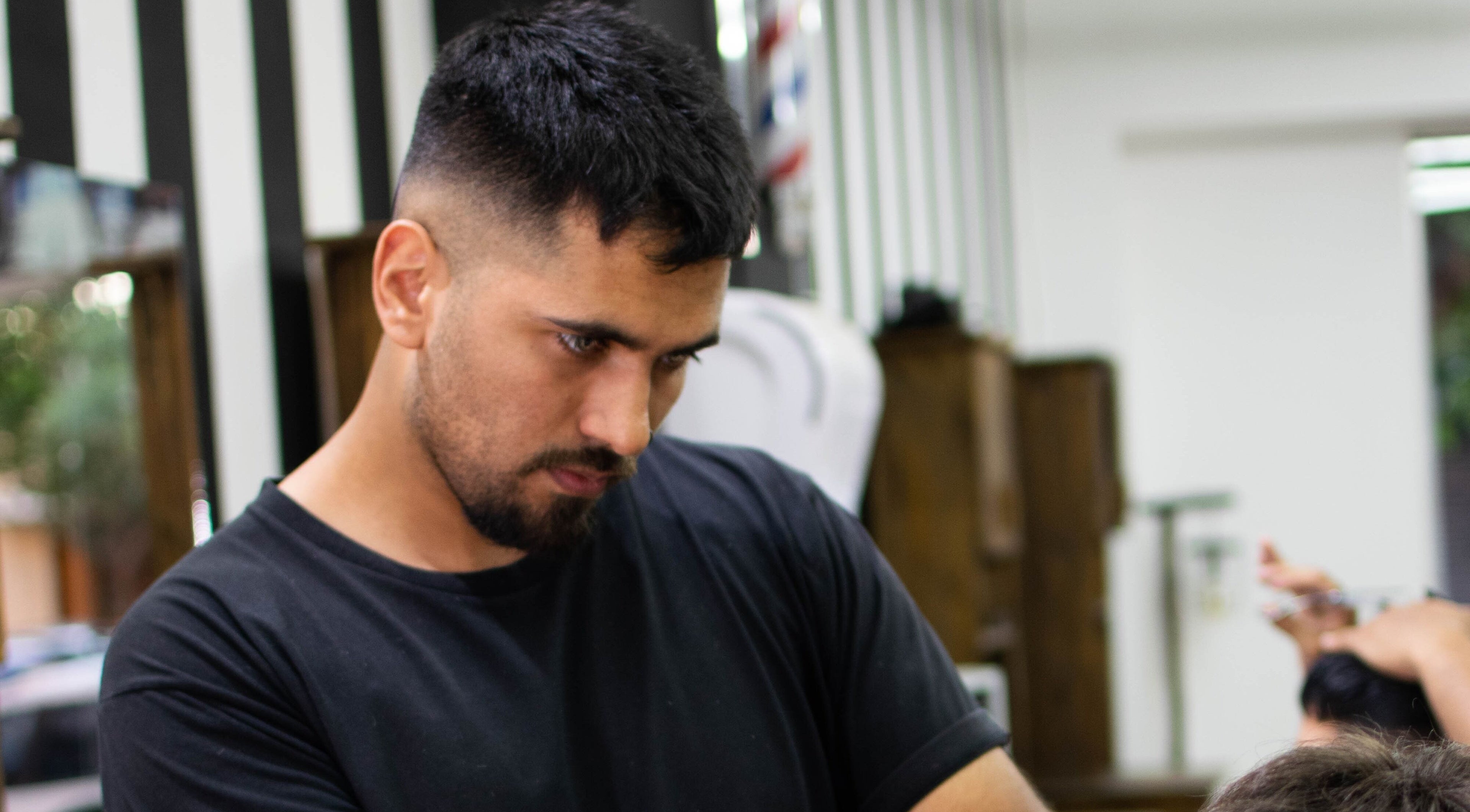 Barbero experto en acción en Charlie, San Juan, San Juan, AR, ofreciendo corte de cabello profesional.