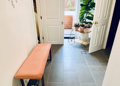 Warm and inviting entrance area at Spa Maluge in Hoboken, New Jersey, US with a plant and pink seating.