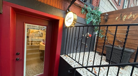 Charming entrance of Spa Maluge in Hoboken, New Jersey, US showcasing a rustic red door and inviting ambiance.