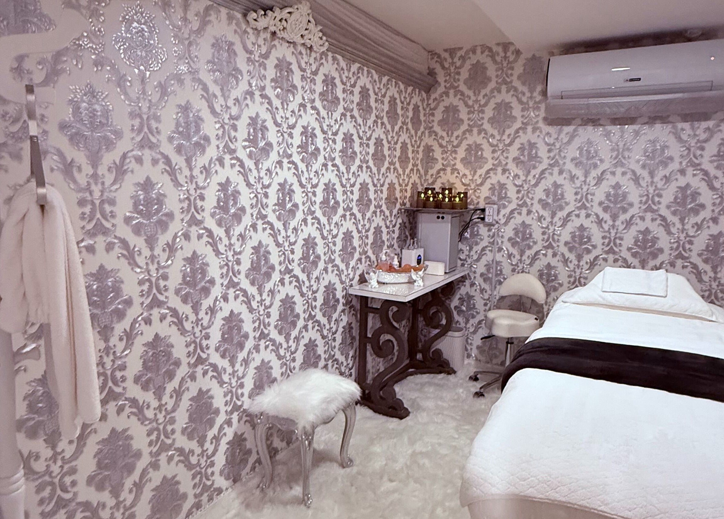 Luxurious treatment room at Spa Maluge, Hoboken, New Jersey, US featuring ornate wallpaper and plush bedding.