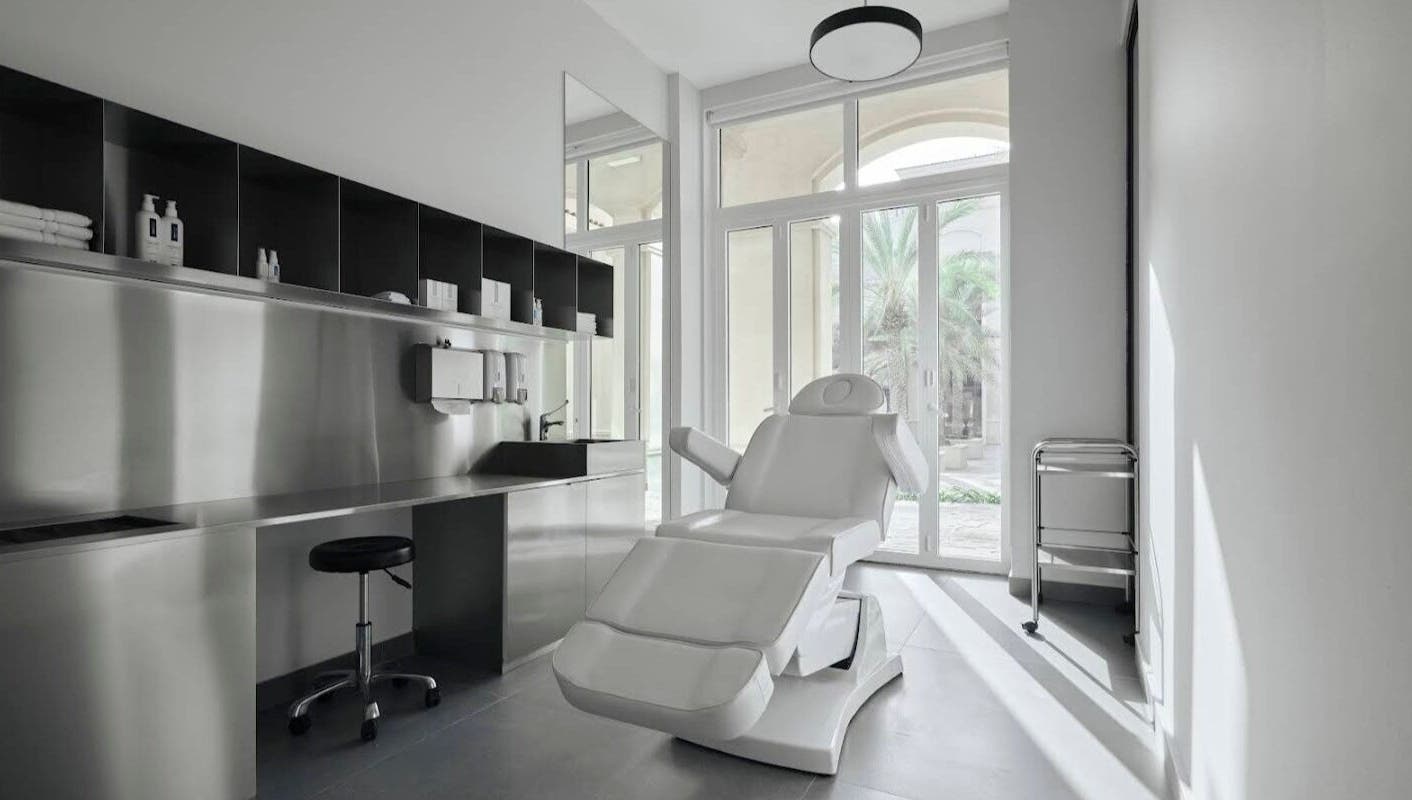 Spacious, modern treatment room at Elegant Ink Studio, Abu Dhabi, Abu Dhabi, AE with a reclining chair and large windows.