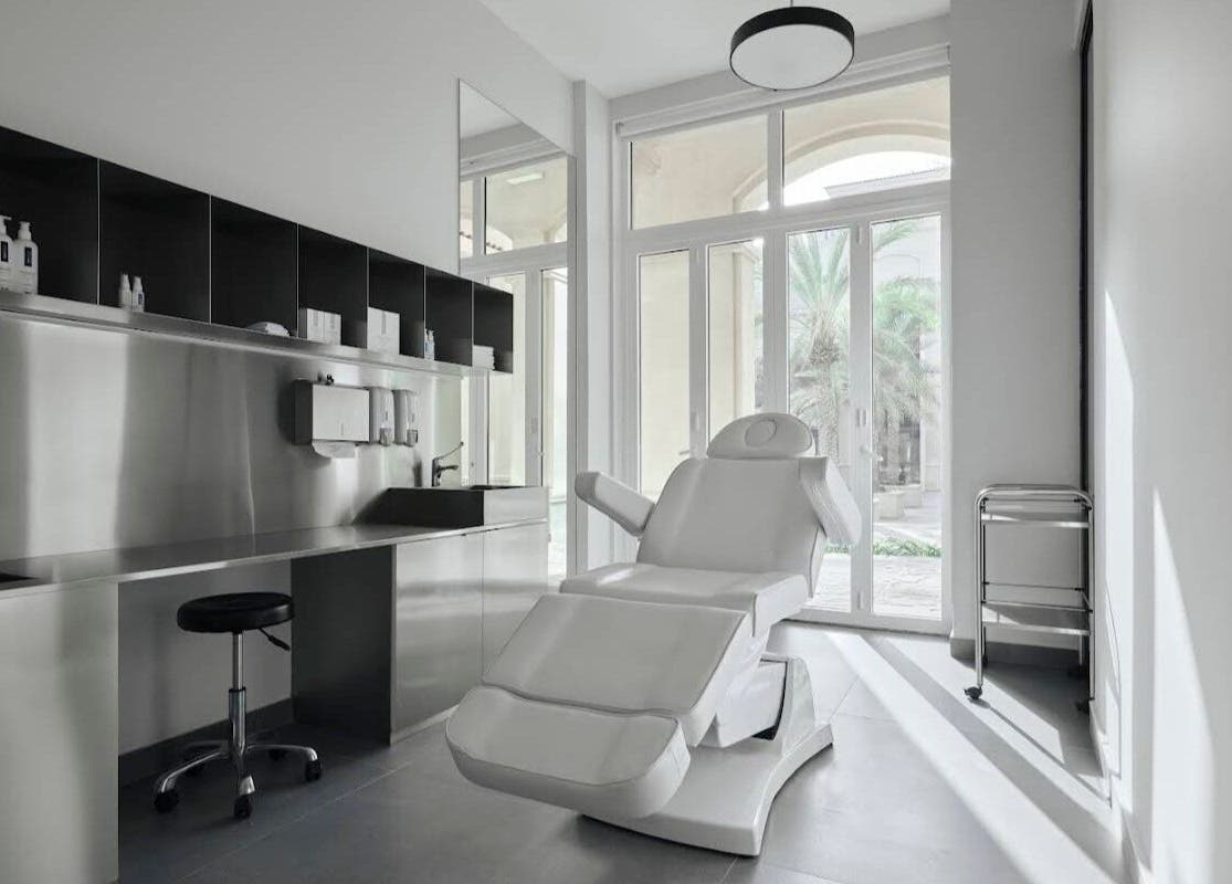 Spacious, modern treatment room at Elegant Ink Studio, Abu Dhabi, Abu Dhabi, AE with a reclining chair and large windows.