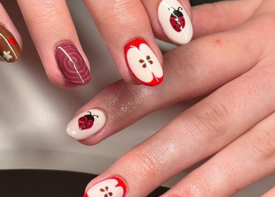 Artistic ladybug and apple nail art at Madison - Beauty Studio in Poole, England, GB.