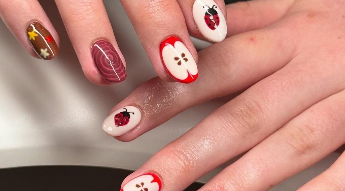 Artistic ladybug and apple nail art at Madison - Beauty Studio in Poole, England, GB.