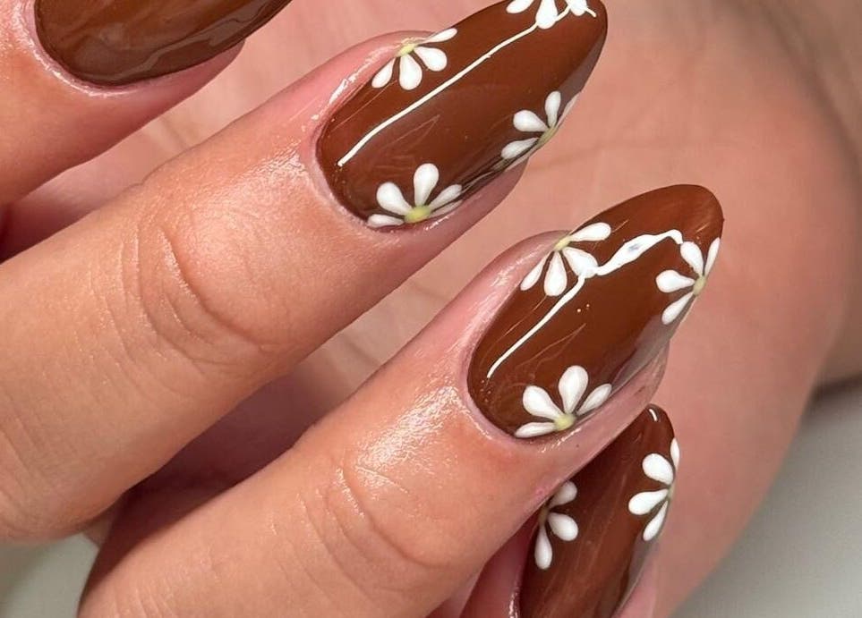 Elegant brown nails with white floral design at Madison - Beauty Studio, Poole, England, GB.