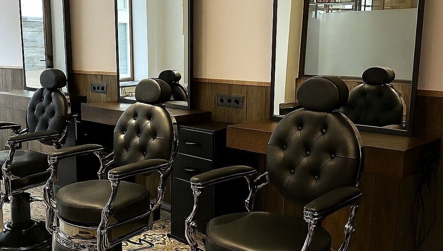 Interior moderno de MBbarber Eeklo en Eeklo, Vlaanderen, BE, con elegantes sillas de barbero.