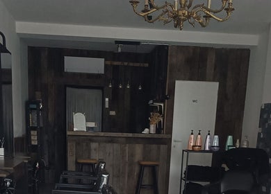 Interior elegante de MBbarber Eeklo en Eeklo, Vlaanderen, BE, con detalles de madera y decoración moderna.