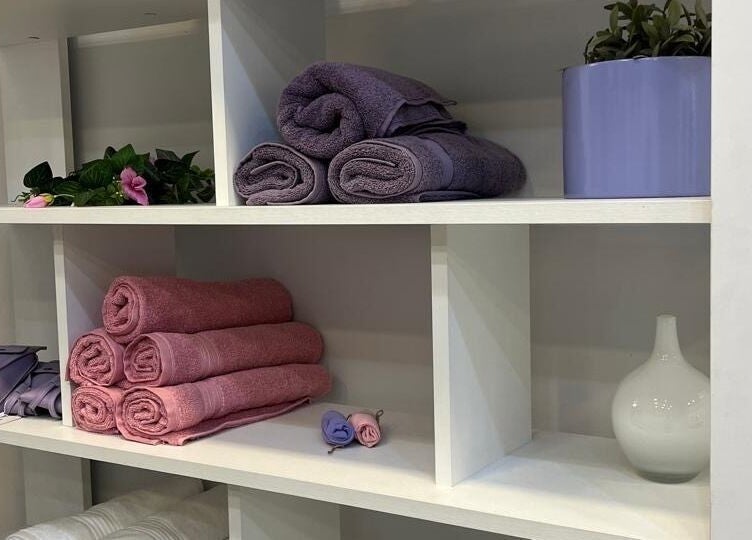 رفوف منظمة بمناشف وأوعية لزهور في Beauty Forever Salon، الخبر، المنطقة الشرقية، السعودية.