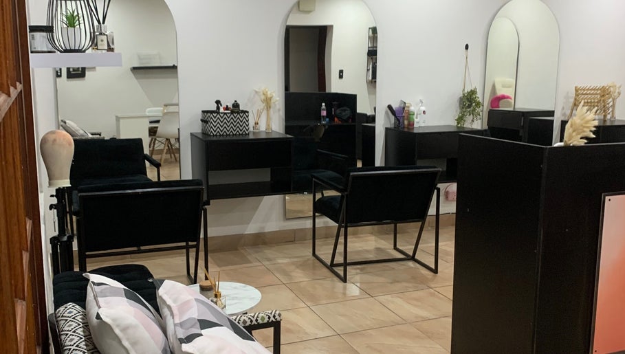 Inside The Masq Salon, Benoni, Gauteng, ZA; sleek black styling chairs and modern decor create a chic atmosphere.