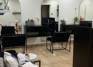 Inside The Masq Salon, Benoni, Gauteng, ZA; sleek black styling chairs and modern decor create a chic atmosphere.