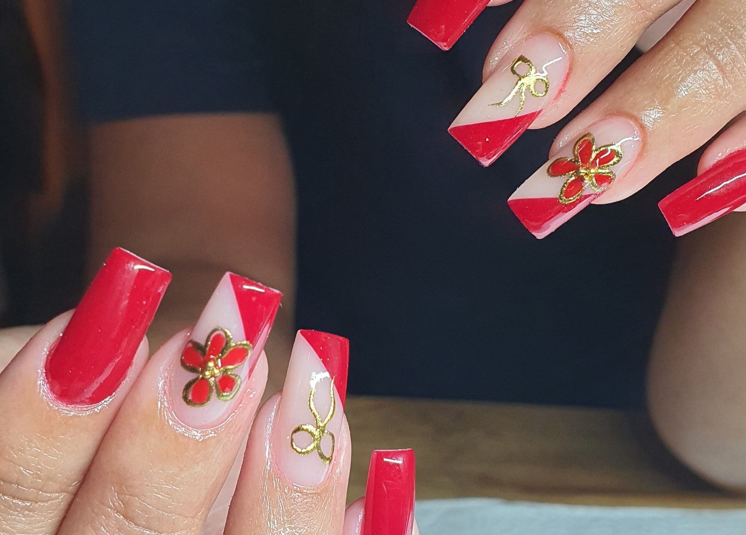 Elegant red nails with gold floral designs from Pink_Aura_Nails, Cape Town, Western Cape, ZA.