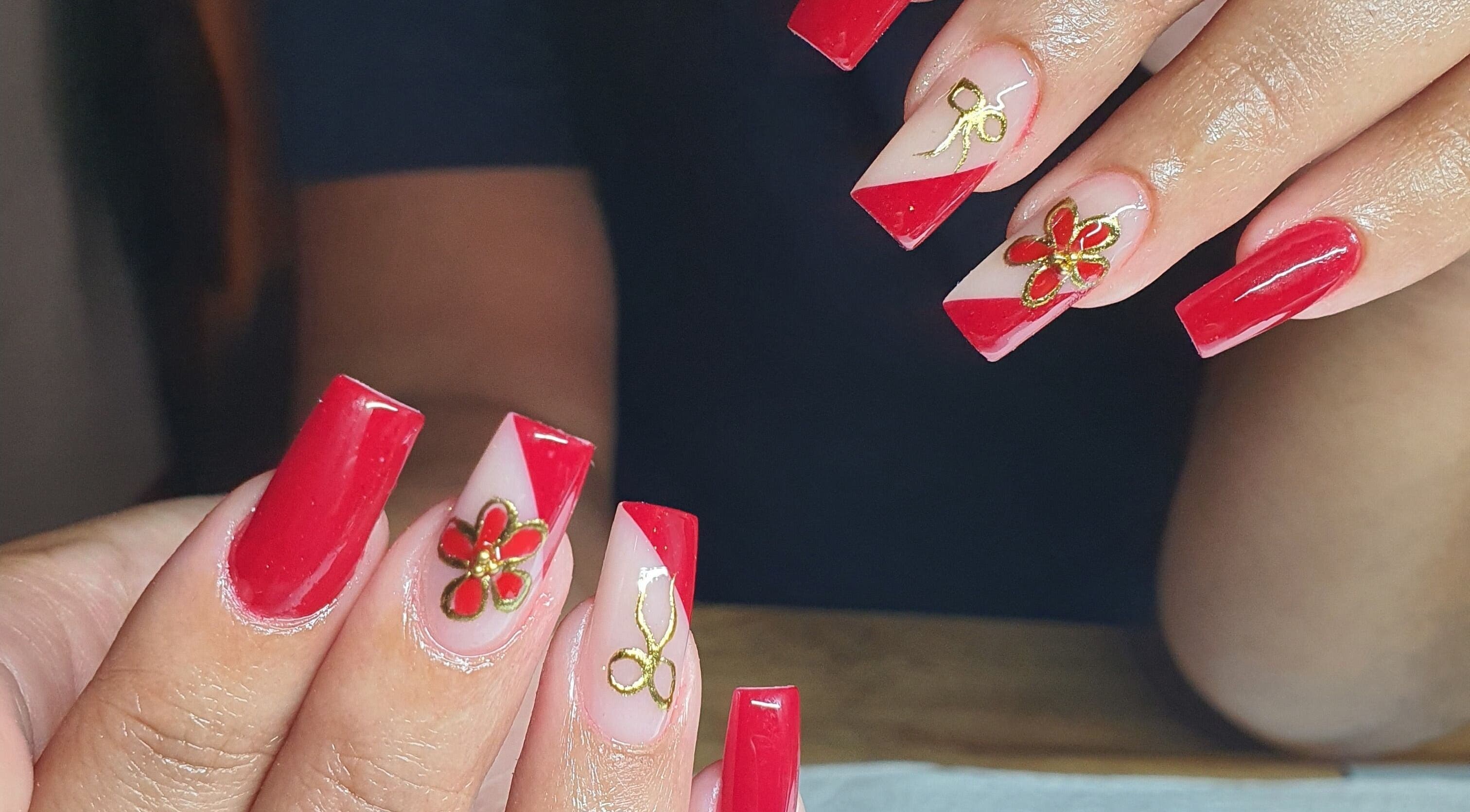 Elegant red nails with gold floral designs from Pink_Aura_Nails, Cape Town, Western Cape, ZA.