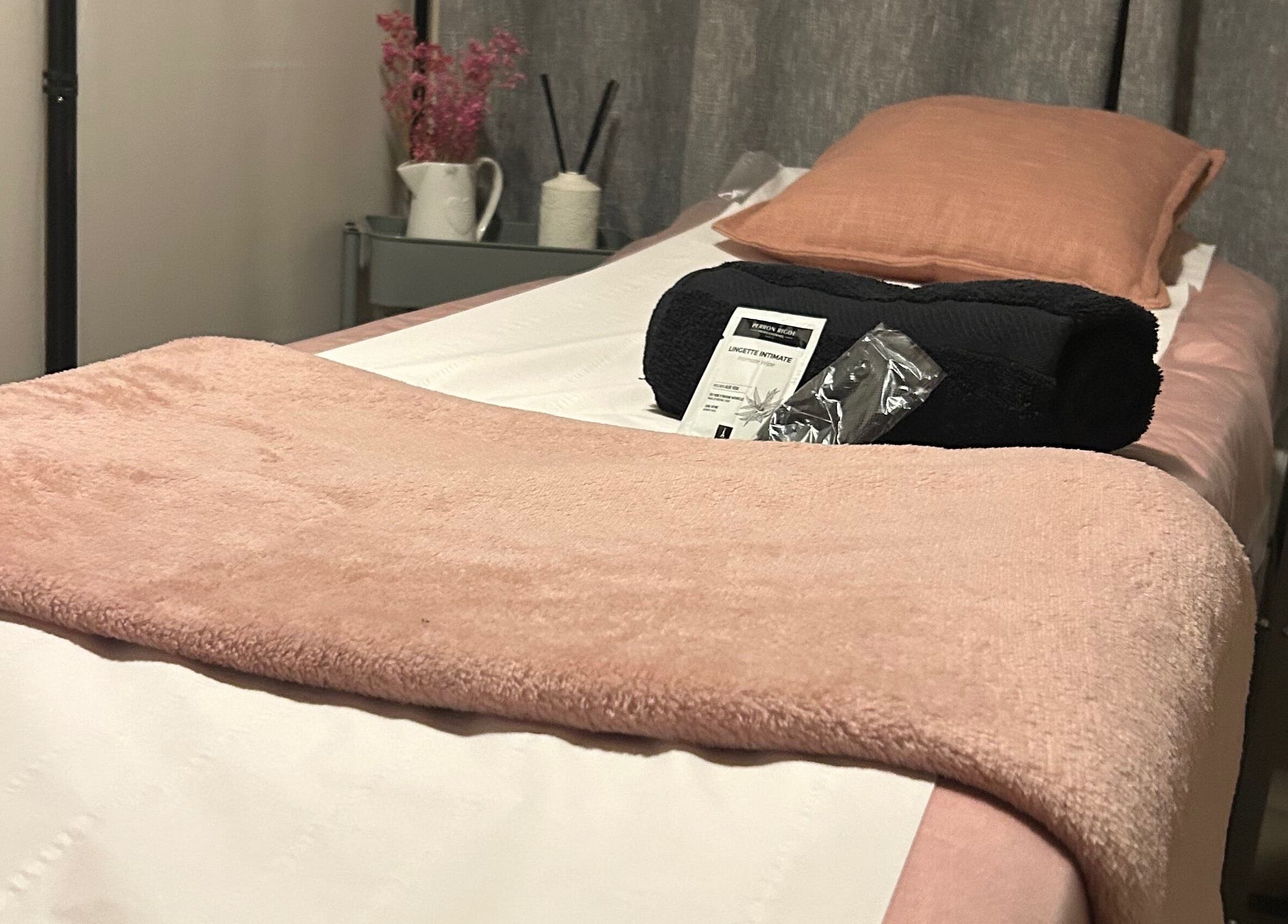A peaceful waxing room at Bare & Bonnie Waxing in Banbury, England, GB with a neatly arranged bed and soft pink linens.