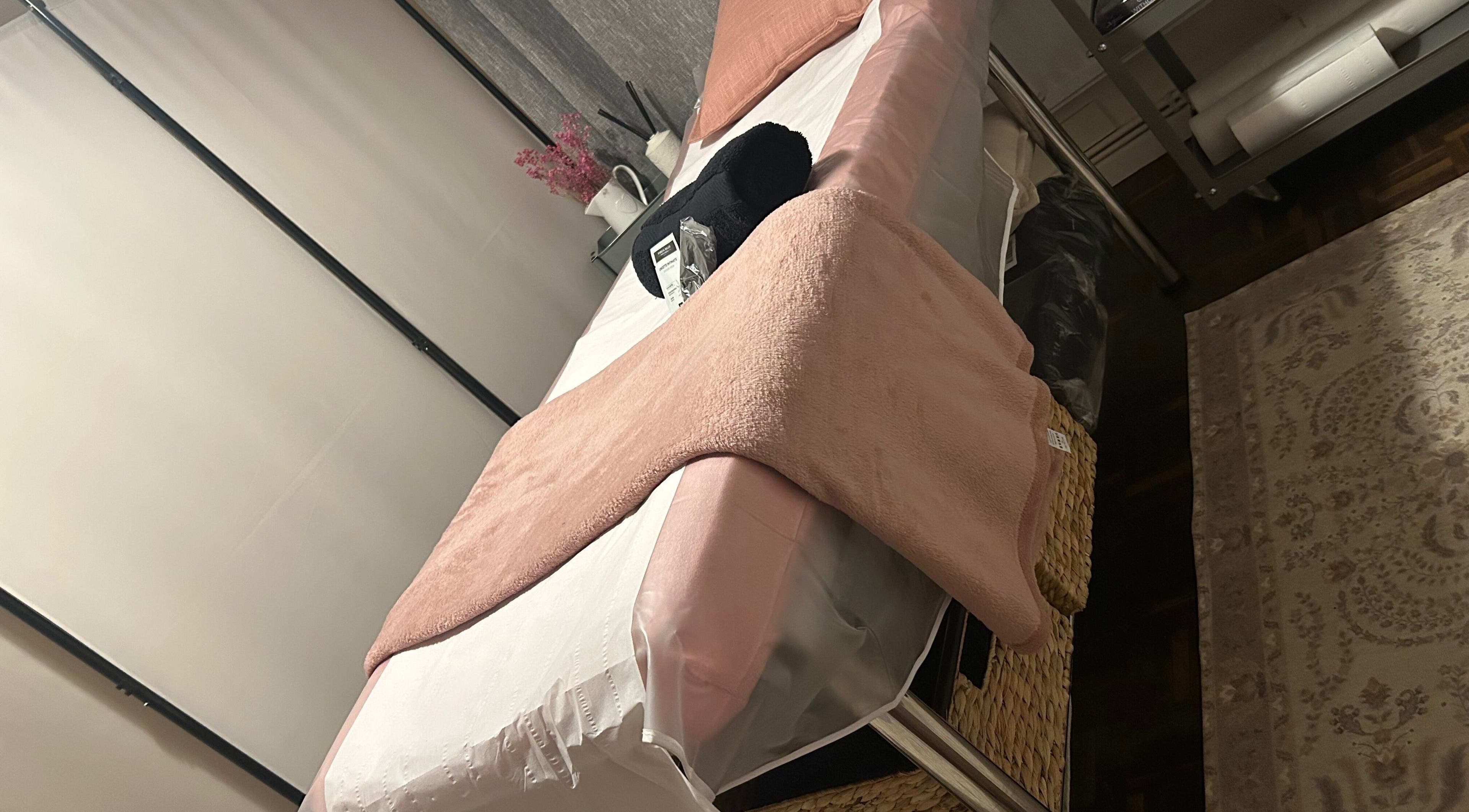 Cozy waxing room at Bare & Bonnie Waxing, Banbury, England, GB, featuring a plush bed with soft pink accents.