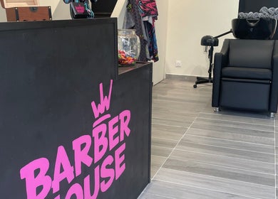 Réception élégante de Barber House à Calvi, Corse, FR, avec fauteuil de coiffure moderne et décor accueillant.