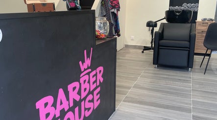 Réception élégante de Barber House à Calvi, Corse, FR, avec fauteuil de coiffure moderne et décor accueillant.