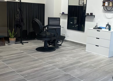 Intérieur moderne de Barber house à Calvi, Corse, FR avec fauteuil de barbier noir.