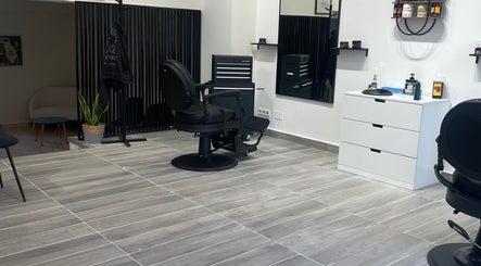 Intérieur moderne de Barber house à Calvi, Corse, FR avec fauteuil de barbier noir.