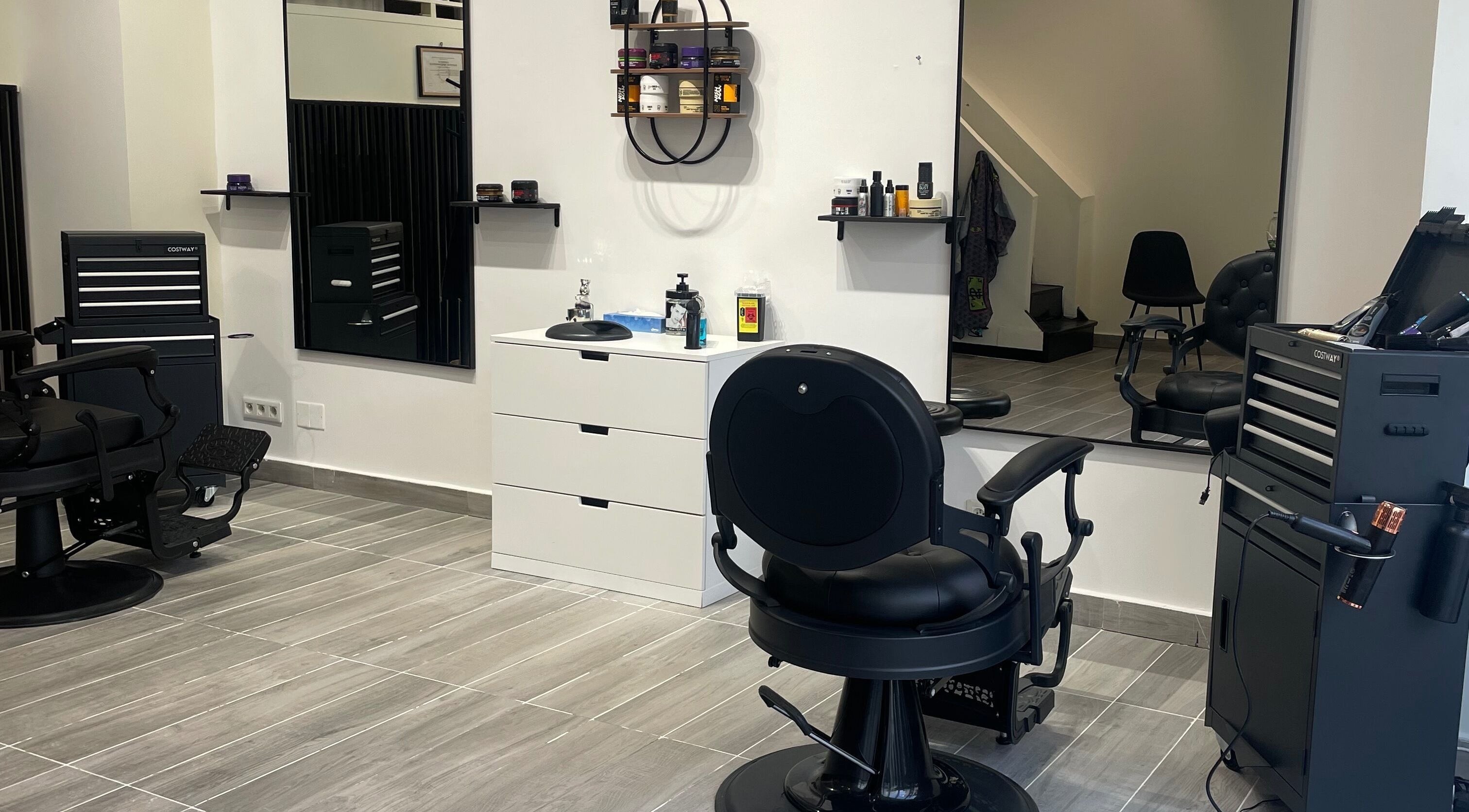 Intérieur moderne du Barber House à Calvi, Corse, FR avec sièges noirs et décoration épurée.