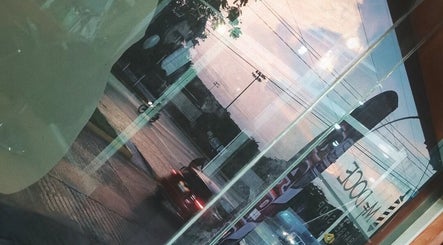 Vista urbana reflejada en la ventana de M DOCE BARBERIA, San Francisco De Campeche, Campeche, MX.