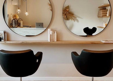 Intérieur chic d'Aiyra Signature à Crozet, Auvergne-rhône-alpes, FR, avec miroirs ronds et fauteuils design.