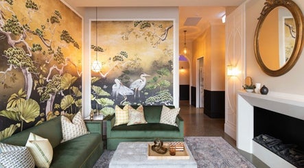 Elegant lounge at Bonded- hair by Tess in Melbourne, Victoria, AU with scenic wallpaper and cozy seating.