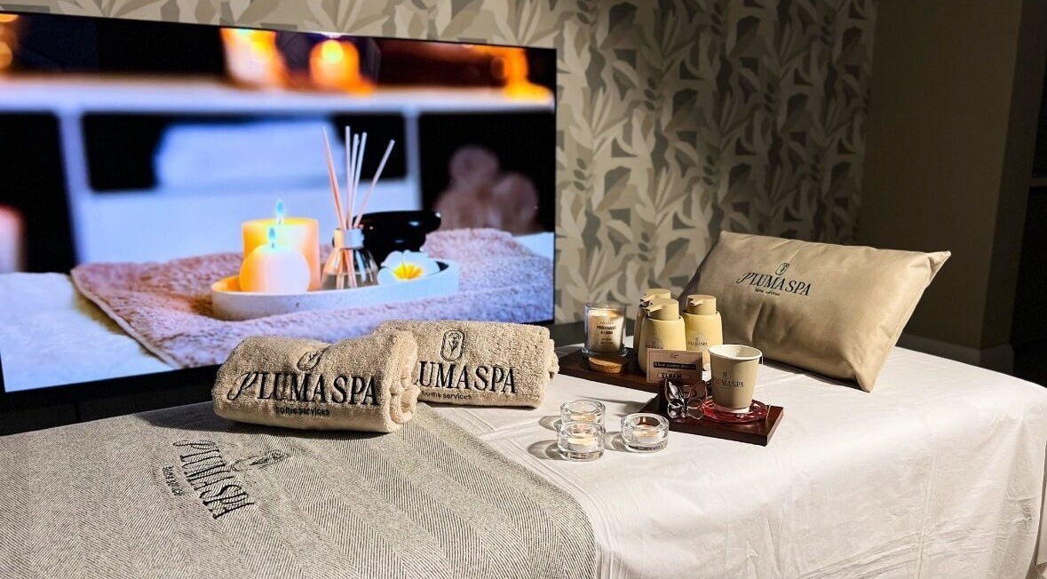 Relaxing spa setup at Pluma Spa Home Service in Riyadh, Riyadh Province, SA showcasing soothing candles and towels.
