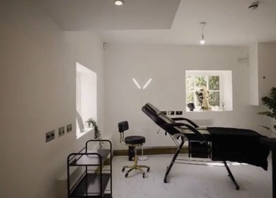 Relaxing treatment room at Abigail Louise Aesthetics, Chester, England, GB with a sleek black chair and modern decor.