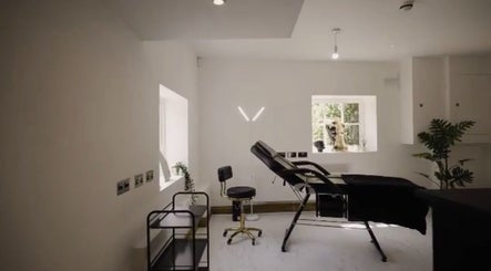 Relaxing treatment room at Abigail Louise Aesthetics, Chester, England, GB with a sleek black chair and modern decor.