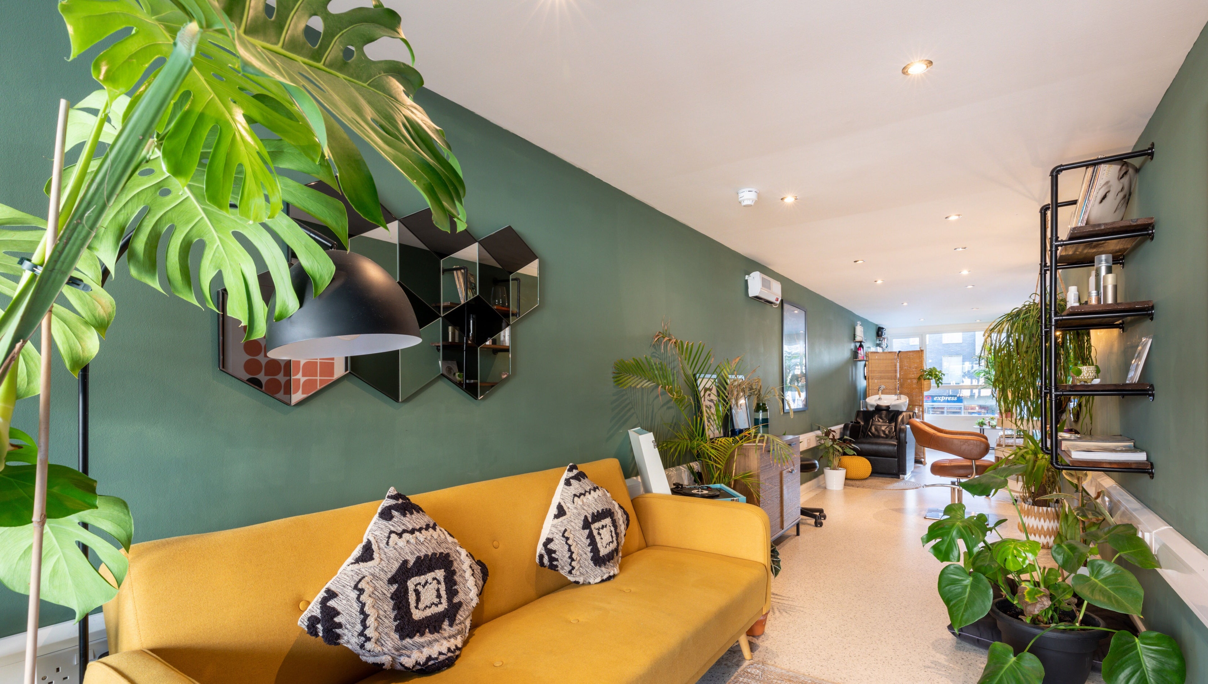 Bright and modern interior of Re:Create Hair Studio in London, England, GB with plants and stylish seating.