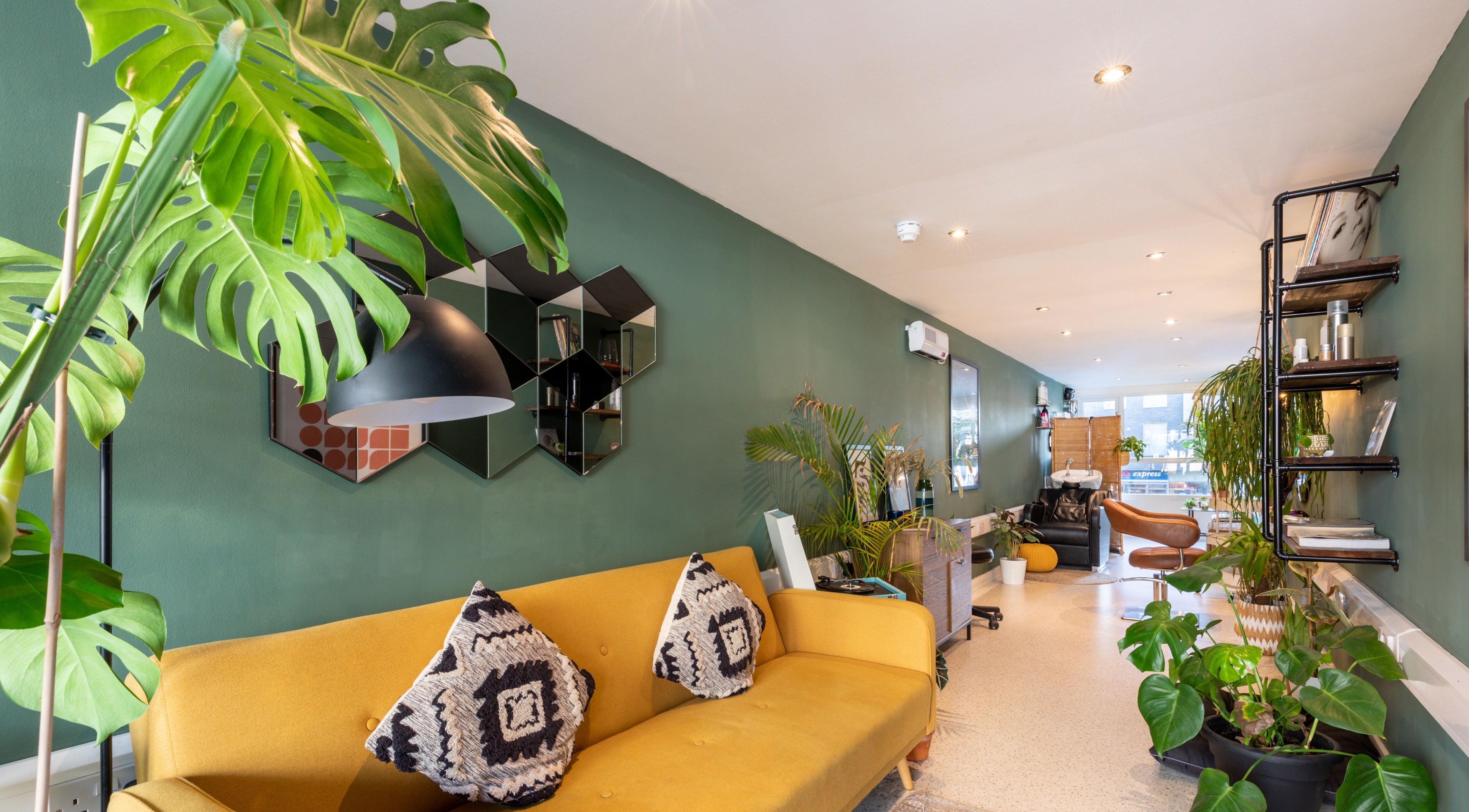 Bright and modern interior of Re:Create Hair Studio in London, England, GB with plants and stylish seating.