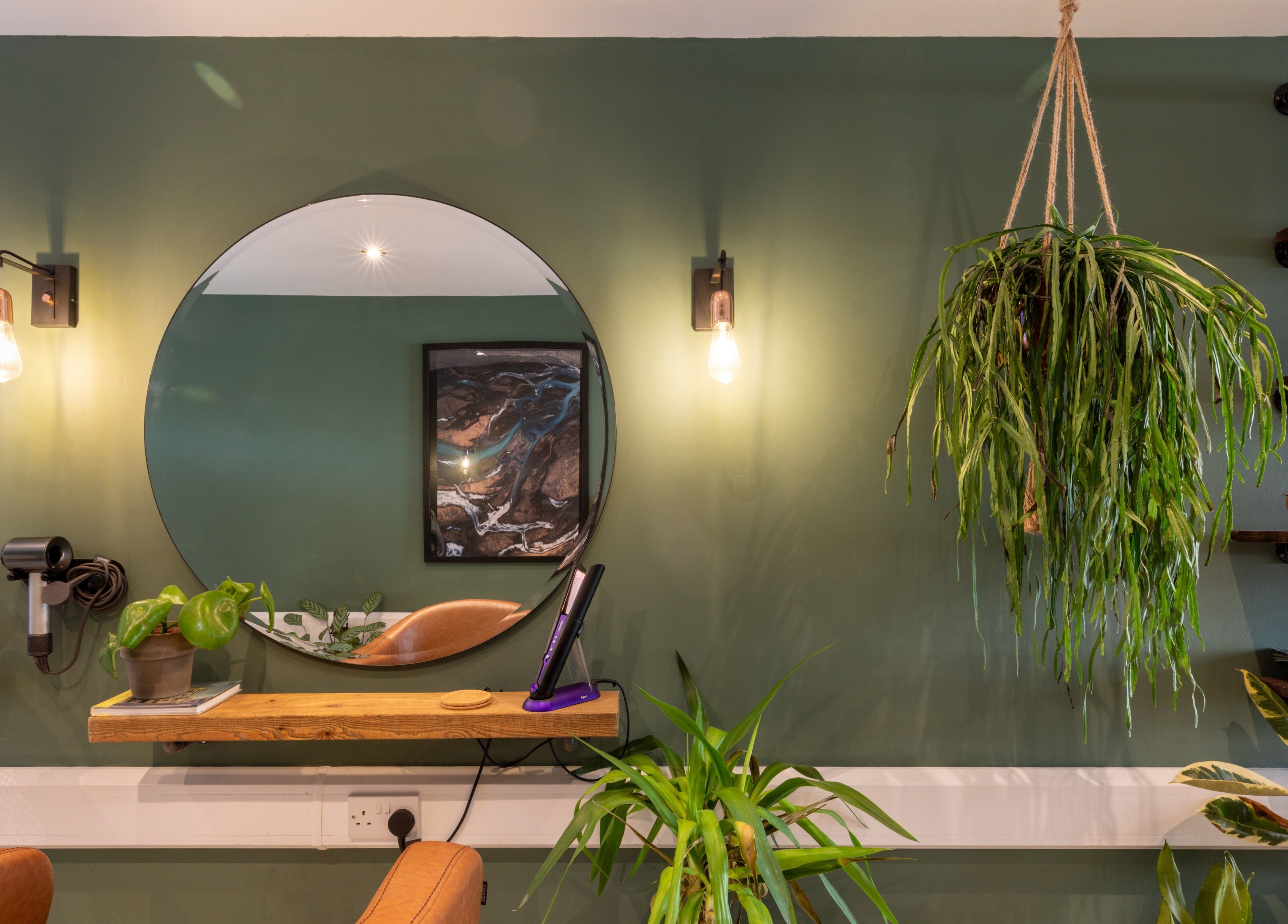 Modern styling station at Re:Create Hair Studio in London, England, GB, featuring green decor and plants.