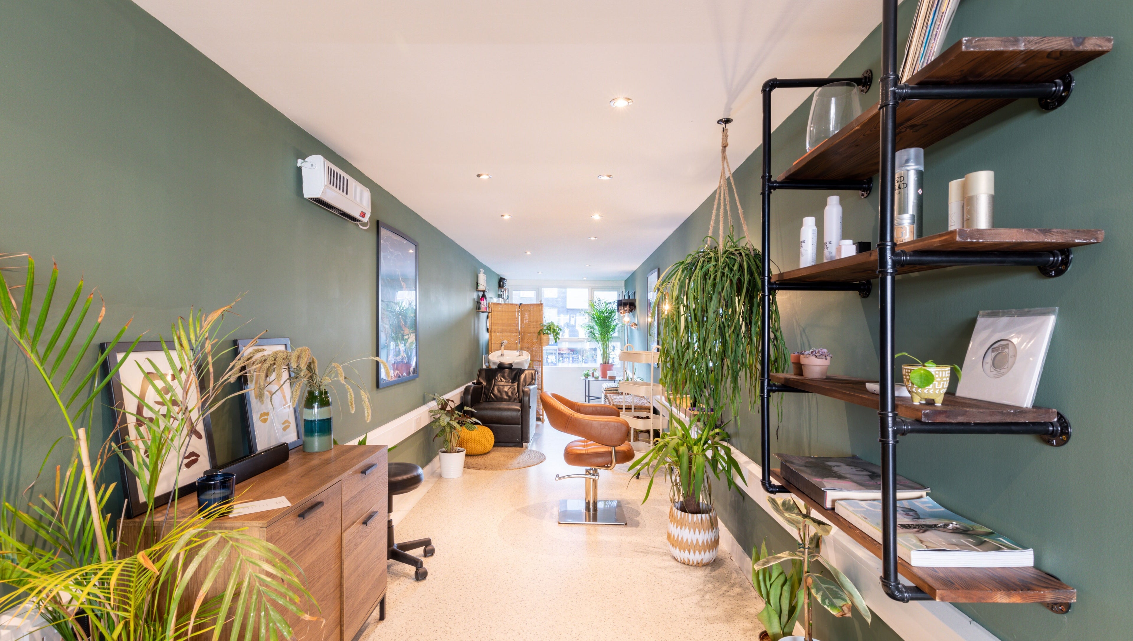 Modern interior of Re:Create Hair Studio in London, England, GB, featuring stylish decor and green plants.