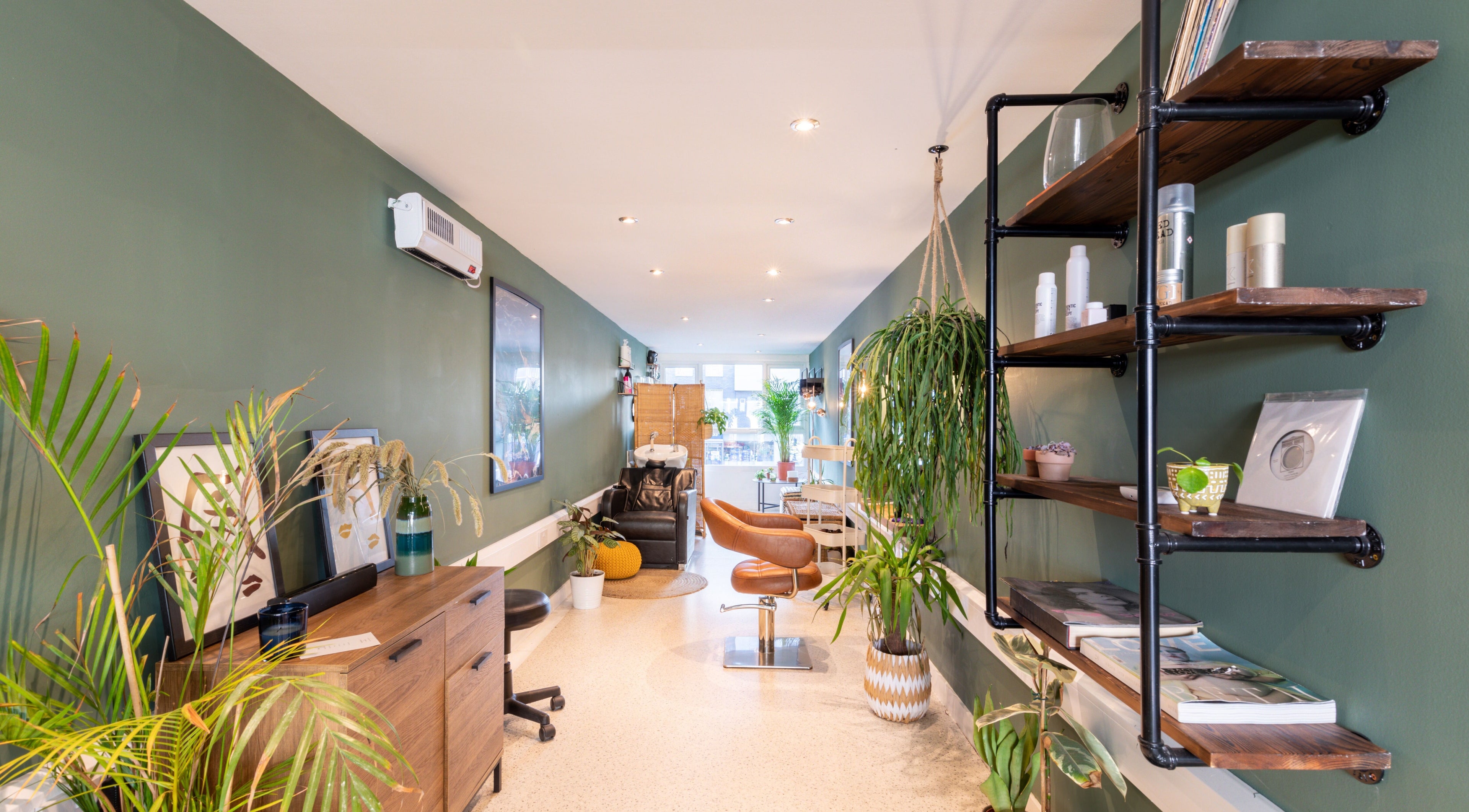 Modern interior of Re:Create Hair Studio in London, England, GB, featuring stylish decor and green plants.