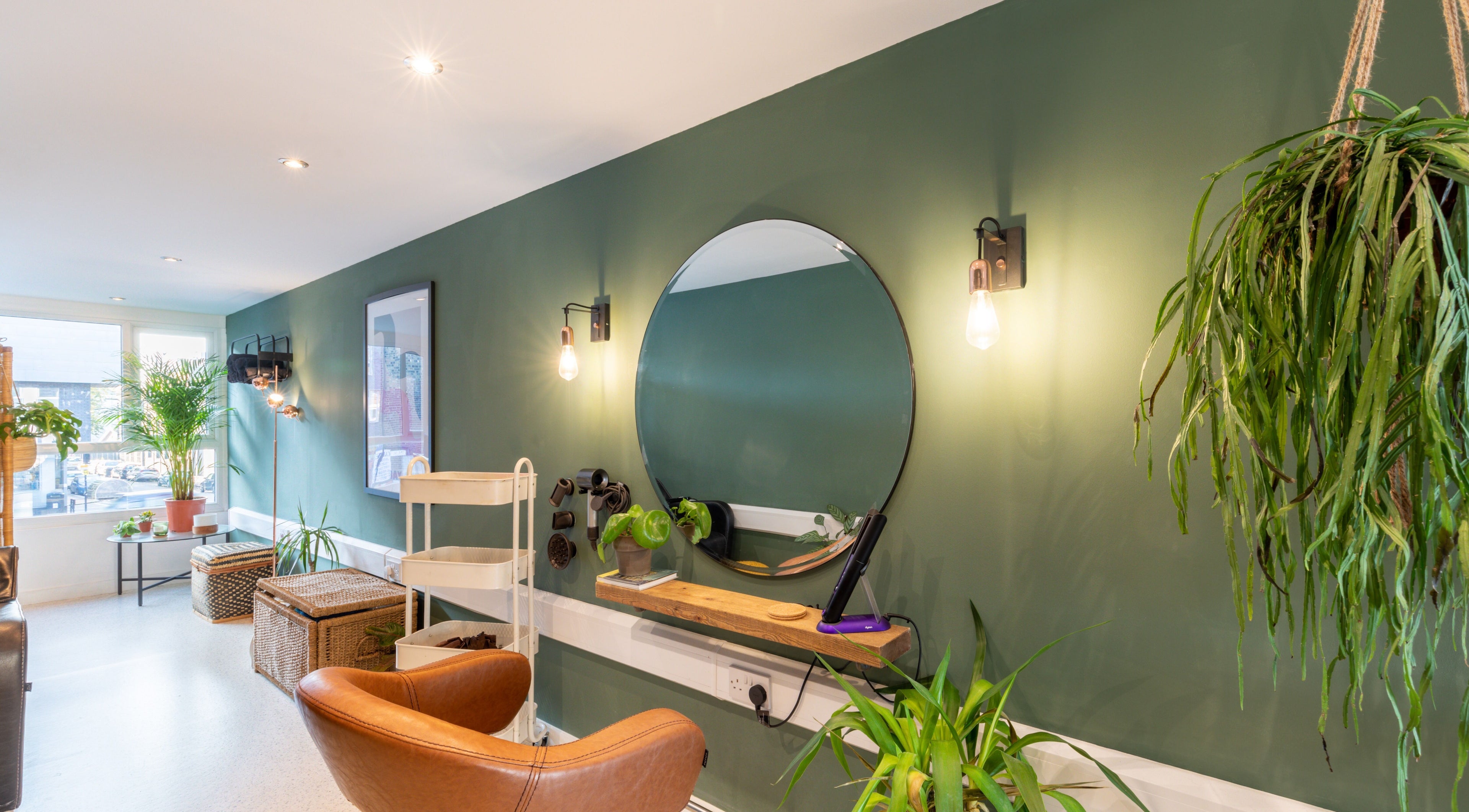 Modern interior of Re:Create Hair Studio in London, England, GB with chic decor and vibrant greenery.