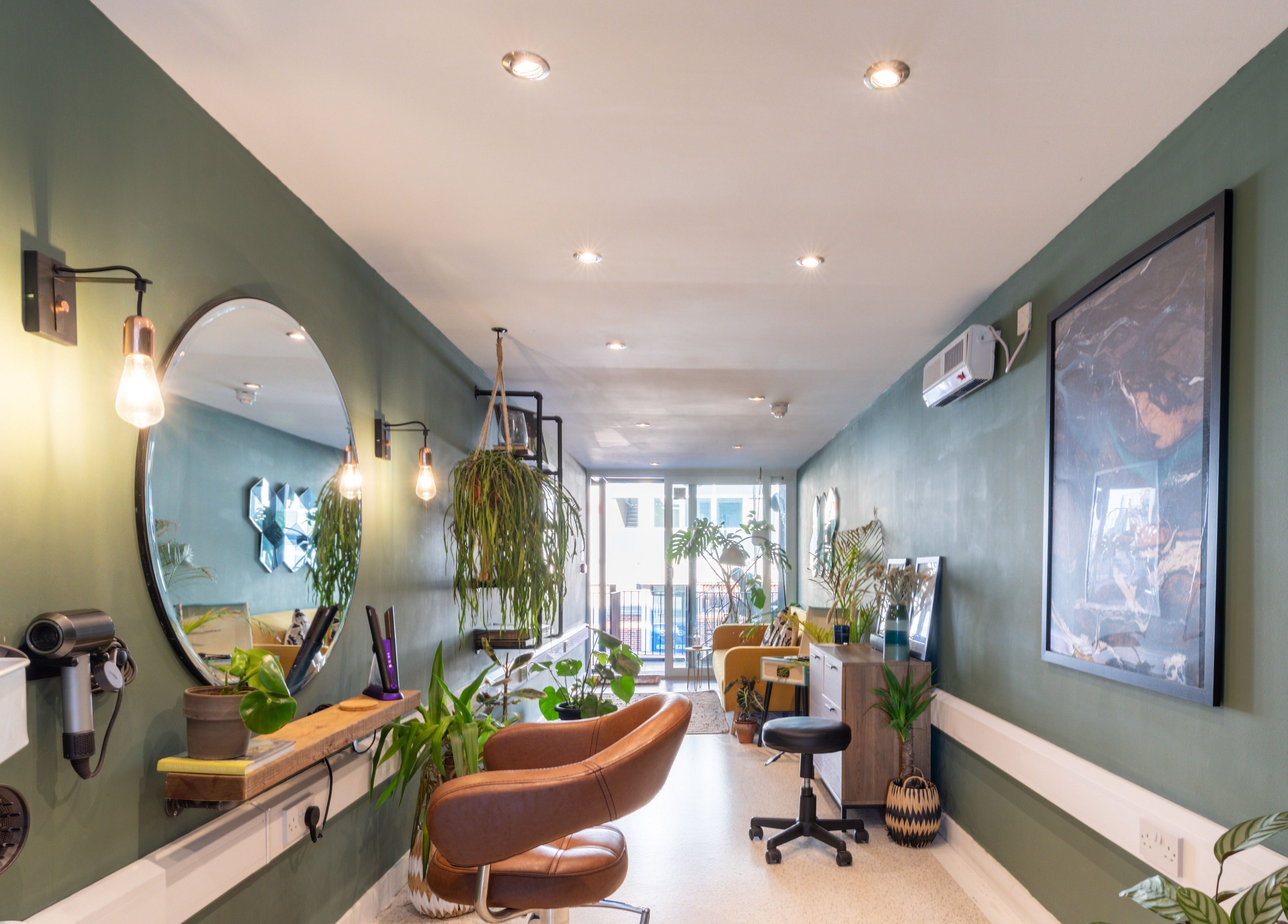 Cozy interior of Re:Create Hair Studio in London, England, GB with modern decor and lush plants.