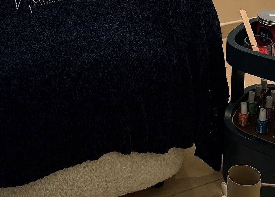 Cozy treatment area at Numi Beauty Studio in Abu Dhabi, Abu Dhabi, AE with nail polishes and spa essentials.