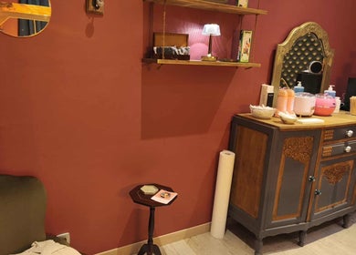 Intérieur élégant de Pin-up'ement Belle à Elbeuf, Normandie, FR, avec meuble vintage et mur rouge.