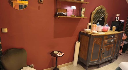 Intérieur élégant de Pin-up'ement Belle à Elbeuf, Normandie, FR, avec meuble vintage et mur rouge.