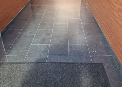 Ingresso elegante di Eleonora Nails ad Almè, Lombardia, IT con pavimento in piastrelle scure.